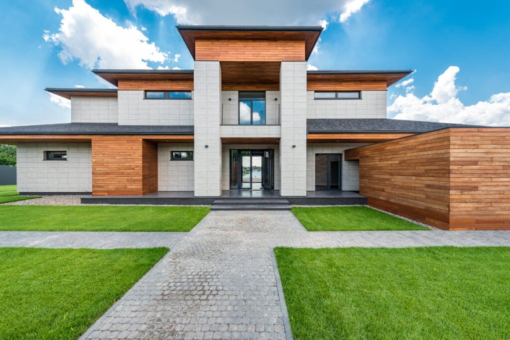 Stunning contemporary house with wood and stone facade set against a vibrant blue sky.