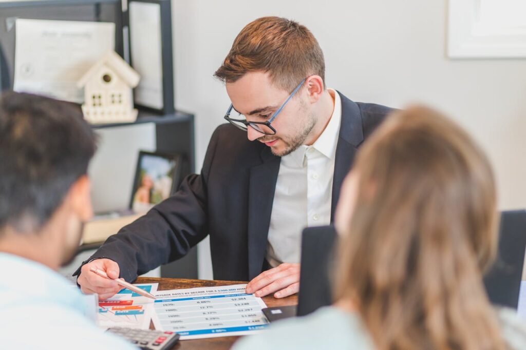 A real estate agent explains mortgage options to clients in an office setting.